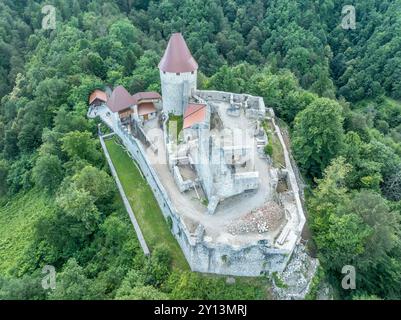 Panoramablick auf die Burg Zovnek, die älteste mittelalterliche Festung Sloweniens mit teilweise restauriertem großen Turm, Burgtor und Zugbrücke Stockfoto