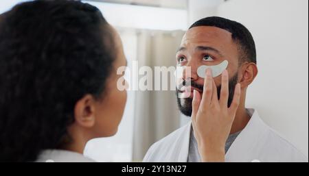 Heim-, Paare- und Hautpflege mit Augenpflastern zur Hydration, dunklem Kreis oder Behandlung, um Schwellungen zu reduzieren. Badezimmer, Frau oder Mann mit Kosmetik für Stockfoto