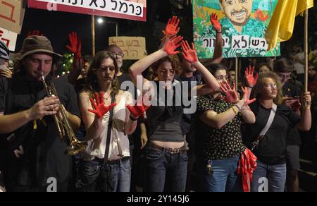 JERUSALEM – 2. SEPTEMBER: Demonstranten singen Slogans, während sie ihre Hände in rot bemalten Händen halten, um israelische Geiseln zu symbolisieren, die während einer Demonstration in der Nähe des Privathauses von Premierminister Benjamin Netanjahu in Gefangenschaft getötet wurden, und rufen die israelische Regierung auf, am 2. September 2024 in Jerusalem einen Vertrag über die Freilassung von Geiseln auszuhandeln. Israel Stockfoto