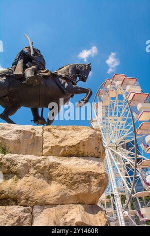 Tirana, Albanien - Mai 30 2024. Denkmal für den albanischen Nationalhelden Gjergj Kastrioti Skanderbeg auf dem Skanderbeg-Platz und das Riesenrad Tirana Eye Stockfoto