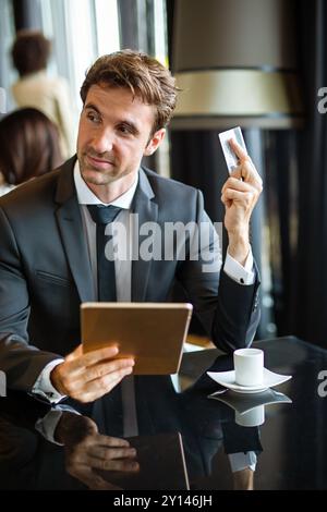 Glücklicher erfolgreicher Geschäftsmann beim Online-Shopping oder zufriedener Unternehmer bei Online-Zahlungen Stockfoto