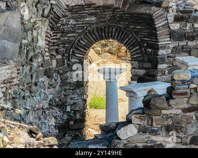 Gerahmte Säule durch Bogen: Ein Blick auf die antike mazedonische Stadt Stobi. Stockfoto