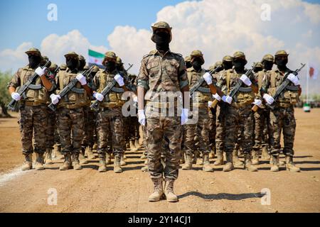 Aleppo, Syrien. Juli 2021. Im nordsyrischen Land Afrins findet eine militärische Zeremonie für den Abschluss von 2.500 Kämpfern der syrischen Nationalarmee (SNA) statt. Viele Kämpfer der SNA marschierten im Gebiet von Scheich Hadid in Afrin im Nordwesten Aleppos, während andere Motorräder und Pferde fuhren. Bilder von getöteten Kämpfern der syrischen Nationalarmee sowie die Flagge der syrischen Opposition und die türkische Flagge wurden bei der Veranstaltung gezeigt. Die SNA ist eine Koalition bewaffneter syrischer Gruppen, die gegen die Regierung von Präsident Bashar Al-Assad sind und mit der Türkei verbündet sind. Der Kopf der Syri Stockfoto