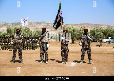 Aleppo, Syrien. Juli 2021. Im nordsyrischen Land Afrins findet eine militärische Zeremonie für den Abschluss von 2.500 Kämpfern der syrischen Nationalarmee (SNA) statt. Viele Kämpfer der SNA marschierten im Gebiet von Scheich Hadid in Afrin im Nordwesten Aleppos, während andere Motorräder und Pferde fuhren. Bilder von getöteten Kämpfern der syrischen Nationalarmee sowie die Flagge der syrischen Opposition und die türkische Flagge wurden bei der Veranstaltung gezeigt. Die SNA ist eine Koalition bewaffneter syrischer Gruppen, die gegen die Regierung von Präsident Bashar Al-Assad sind und mit der Türkei verbündet sind. Der Kopf der Syri Stockfoto