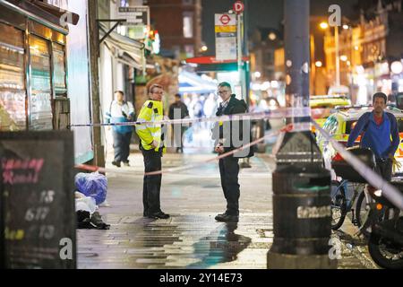 London, Großbritannien. September 2024. Polizeibeamte bewachen eine Absperrung am Ort eines Säureangriffs, der am 4. September 2024 in der Kilburn High Road stattfand. Ein Mann wird derzeit im Krankenhaus für etwas behandelt, was man als keine lebensbedrohlichen Verletzungen glaubt. Foto: Ben Cawthra/SIPA USA Credit: SIPA USA/Alamy Live News Stockfoto