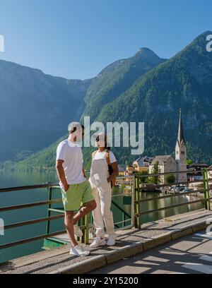 Ein Paar steht an einem malerischen Aussichtspunkt in Hallstatt, Österreich, und genießt die Sonne und die atemberaubende Aussicht auf den See und die majestätischen Berge, die dieses charmante Dorf umgeben. Stockfoto