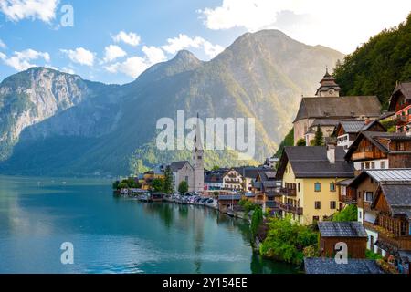 Eingebettet zwischen majestätischen Bergen zeigt Hallstatt seine bezaubernde Architektur entlang des ruhigen Sees, die goldene Sonnenstrahlen reflektiert, wenn der Tag zu Ende geht. Ein fesselnder Moment erwartet Sie. Stockfoto