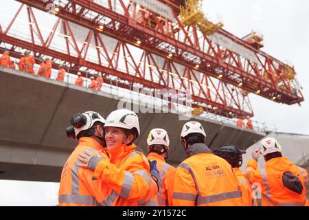 Die Arbeiter feiern, als das letzte Deckstück des 2,1 km langen Viadukts des HS2, das das Colne Valley durchquert, abgesenkt und am Maple Cross in Hertfordshire fixiert wird. Eine Brückenbaumaschine auf dem Viadukt wird verwendet, um die letzten von 1.000 Decksegmenten in Position zu senken, und nach mehr als zwei Jahren Bauzeit wird das Gebäude den Rekord der längsten Brücke Großbritanniens von der Tay Bridge in Schottland aufnehmen, nach fast 140 Jahren. Bilddatum: Donnerstag, 5. September 2024. Stockfoto