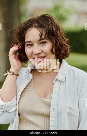 Eine fröhliche junge Frau schwelgt in der Wärme des Sommers und sonnt sich im üppigen Grün des Parks. Stockfoto