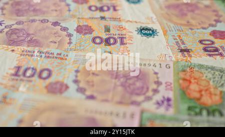 Argentinische 100-Pesos-Banknoten in verschiedenen Arrangements mit lebhaften Farben und detaillierten Designs, die argentinisches Geld und fina darstellen Stockfoto