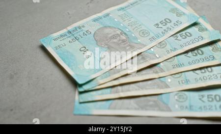 Indische Banknoten von 50 Rupien auf einer Betonoberfläche, die Währung, Finanzen und die indische Wirtschaft betonen. Stockfoto