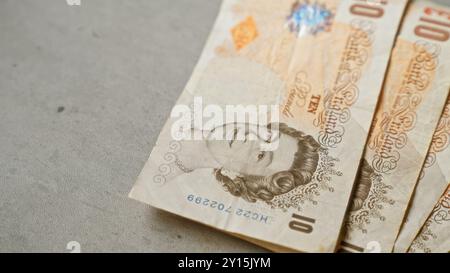 Britische zehn-Pfund-Banknoten mit dem Porträt der Königin sind ordentlich auf einer Betonoberfläche angeordnet, die englands Währung in einem Minimalisti hervorheben Stockfoto