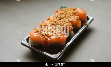 Sushi-Platte mit frischem Lachs mit knusprigen Belägen auf hellem Hintergrund Stockfoto