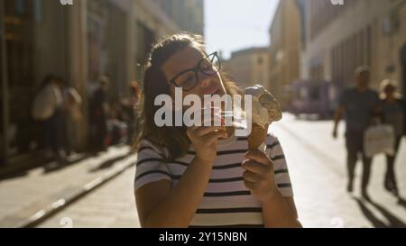 Eine junge hispanische Frau genießt an einem sonnigen Tag in lecce, einer historischen Stadt in apulien, italien, Eis. Stockfoto