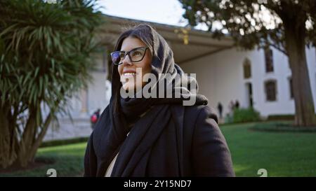 Eine wunderschöne, junge, brünette lateinfrau in Brille und Schal, die den historischen topkapi-Palast in istanbul besucht. Stockfoto