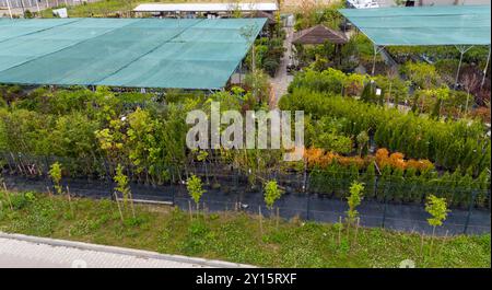 StandardLuftaufnahme einer Gartenanlage mit verschiedenen Pflanzen und Bäumen unter Schutznetz. Wege trennen Grünflächen und zeigen ein Stockfoto