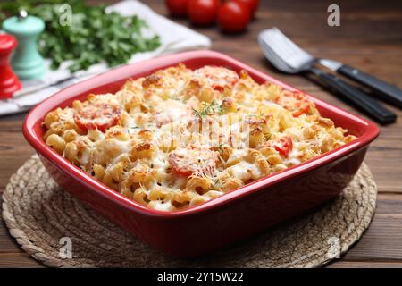 Köstliche al-Forno-Pasta in Backform auf Holztisch, Nahaufnahme Stockfoto