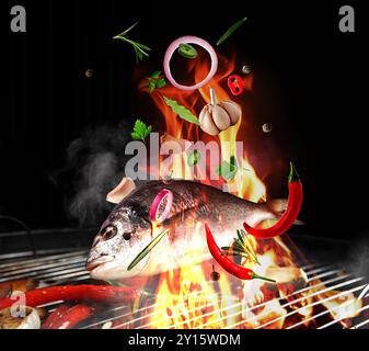 Meeresfisch, Kräuter, Gewürze und Gemüse, das vor schwarzem Hintergrund geröstet wird. Grillgerichte Stockfoto