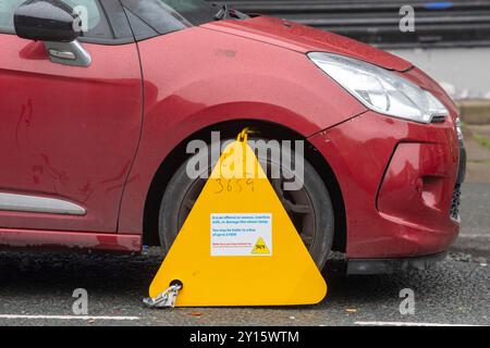 Ein Auto, das wegen Nichtentrichtung der Kfz-Verbrauchsteuer in Großbritannien an der High Street in Queensbury, West Yorkshire, Großbritannien, eingeklemmt wurde. Quelle: Windmill Images/Alamy Live News Stockfoto