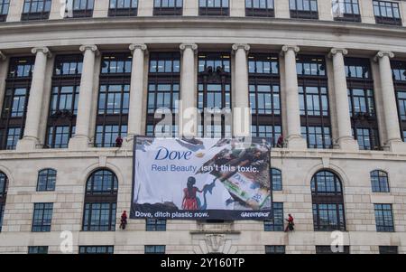 London, Großbritannien. September 2024. Greenpeace-Aktivisten entfalten ein massives Banner auf dem Unilever-Hauptquartier. Aktivisten blockierten auch die Eingänge zum Gebäude und sperrten sich in riesige Nachbildungen von Dove Deodorant Sticks ein, um gegen die Plastikverschmutzung durch Dove Produkte zu protestieren. Quelle: Vuk Valcic/Alamy Live News Stockfoto