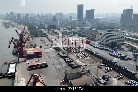 JIUJIANG, CHINA - 5. SEPTEMBER 2024 - Ein Kran lädt Mais von einem Frachtschiff, das am Yangtze-Fluss-Terminal angedockt ist, in einen Container an der Spezialeisenbahn Stockfoto