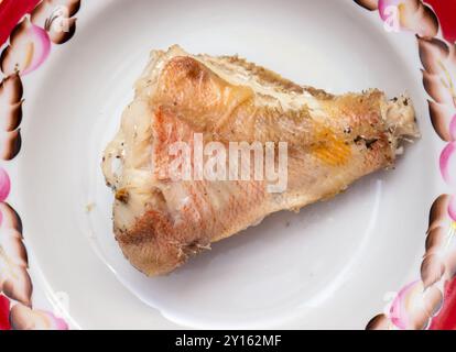 Ein Stück gebratener Fisch auf einem Teller. Stockfoto