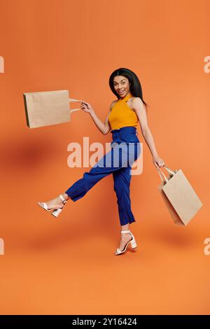 Eine lebendige Frau präsentiert ihre Einkaufstaschen vor farbenfroher Kulisse. Stockfoto