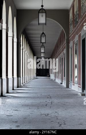 München, Deutschland - 22. Dezember 2023 - perspektivischer Blick auf den langen Korridor mit antiker Laterne, die von der Decke hängt, und wunderschönen Säulen im Hofgartenark Stockfoto