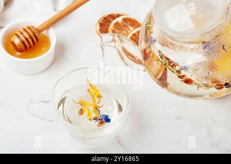 Frau Hand gießt Bio-Bergmischung beruhigenden Kräutertee. Wellness-Retreat mit Kräuteraufgüssen Tisch-Setting. Stockfoto