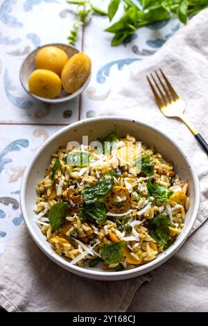 Orzo-Pasta mit gelber Zucchini, eingelegter Zitrone und Basilikum Stockfoto