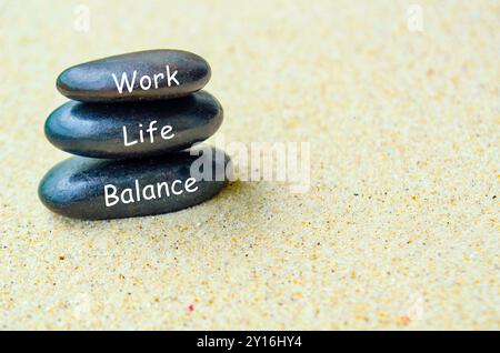 Work Life Balance Text auf schwarzen Zen Steinen am Sandstrand. Work-Life-Balance-Konzept. Stockfoto