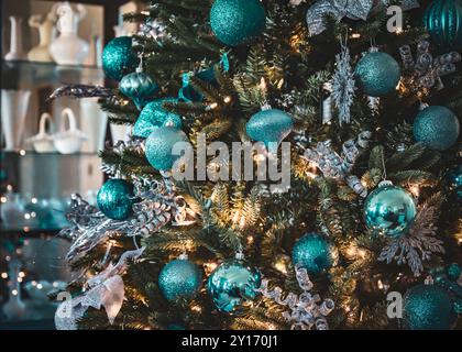 Nahaufnahme von Ornamenten, die an einem gut dekorierten Weihnachtsbaum in gemütlicher Atmosphäre hängen Stockfoto