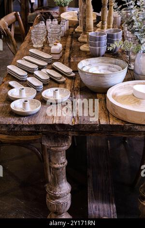 Nahaufnahme eines hölzernen Bauerntischs mit Speisen und Geschirr im Bauernhausstil in Thanksgiving-Umgebung Stockfoto