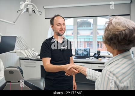 Zahnersatz begrüßt eine ältere Dame in einer Zahnklinik Stockfoto