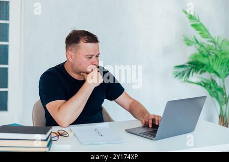 Mann mit Laptop in Büro-Internetarbeit Stockfoto