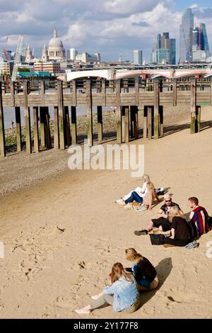 Menschen am Sandstrand, der bei Flut am Southufer der Themse im Zentrum von London, Großbritannien, ausgesetzt ist. Stockfoto