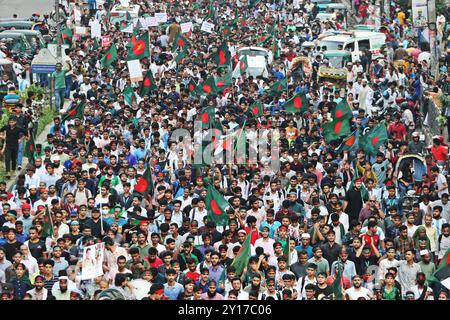 Dhaka, Wari, Bangladesch. September 2024. Demonstranten schwenken Bangladeschs Nationalflagge während des Märtyrermarsches, einer von Studenten organisierten Demonstration gegen Diskriminierung, um einen Monat nach dem Sturz des ehemaligen Premierministers Sheikh Hasina in Dhaka am 5. September 2024 zu feiern. Bangladeschs gestürzter Premierminister Scheich Hasina sollte im Exil in Indien „ruhig bleiben“, bis sie zum Prozess nach Hause gebracht wird, sagte der Interimsführer Muhammad Yunus den indischen Medien am 5. September. Hasina, 76 Jahre alt, floh vor einem Monat mit dem Hubschrauber nach Indien, als Demonstranten in ihrem Palast marschierten, um ihre Herrschaft mit eiserner Faust zu beenden Stockfoto