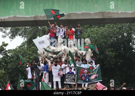 Dhaka, Wari, Bangladesch. September 2024. Demonstranten schwenken Bangladeschs Nationalflagge während des Märtyrermarsches, einer von Studenten organisierten Demonstration gegen Diskriminierung, um einen Monat nach dem Sturz des ehemaligen Premierministers Sheikh Hasina in Dhaka am 5. September 2024 zu feiern. Bangladeschs gestürzter Premierminister Scheich Hasina sollte im Exil in Indien „ruhig bleiben“, bis sie zum Prozess nach Hause gebracht wird, sagte der Interimsführer Muhammad Yunus den indischen Medien am 5. September. Hasina, 76 Jahre alt, floh vor einem Monat mit dem Hubschrauber nach Indien, als Demonstranten in ihrem Palast marschierten, um ihre Herrschaft mit eiserner Faust zu beenden Stockfoto