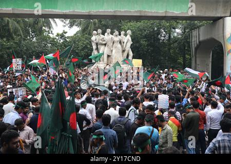 Dhaka, Wari, Bangladesch. September 2024. Demonstranten schwenken Bangladeschs Nationalflagge während des Märtyrermarsches, einer von Studenten organisierten Demonstration gegen Diskriminierung, um einen Monat nach dem Sturz des ehemaligen Premierministers Sheikh Hasina in Dhaka am 5. September 2024 zu feiern. Bangladeschs gestürzter Premierminister Scheich Hasina sollte im Exil in Indien „ruhig bleiben“, bis sie zum Prozess nach Hause gebracht wird, sagte der Interimsführer Muhammad Yunus den indischen Medien am 5. September. Hasina, 76 Jahre alt, floh vor einem Monat mit dem Hubschrauber nach Indien, als Demonstranten in ihrem Palast marschierten, um ihre Herrschaft mit eiserner Faust zu beenden Stockfoto