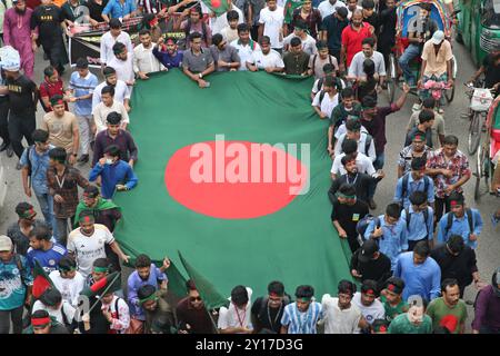 Dhaka, Wari, Bangladesch. September 2024. Demonstranten schwenken Bangladeschs Nationalflagge während des Märtyrermarsches, einer von Studenten organisierten Demonstration gegen Diskriminierung, um einen Monat nach dem Sturz des ehemaligen Premierministers Sheikh Hasina in Dhaka am 5. September 2024 zu feiern. Bangladeschs gestürzter Premierminister Scheich Hasina sollte im Exil in Indien „ruhig bleiben“, bis sie zum Prozess nach Hause gebracht wird, sagte der Interimsführer Muhammad Yunus den indischen Medien am 5. September. Hasina, 76 Jahre alt, floh vor einem Monat mit dem Hubschrauber nach Indien, als Demonstranten in ihrem Palast marschierten, um ihre Herrschaft mit eiserner Faust zu beenden Stockfoto