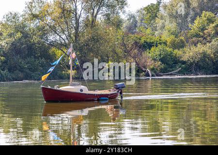 Kleines Boot in ruhigem Wasser eines Stausees Nebenfluss der Maas, herbstliche Laubbäume im Hintergrund, sonniger Herbsttag in Süd-Limburg, Net Stockfoto
