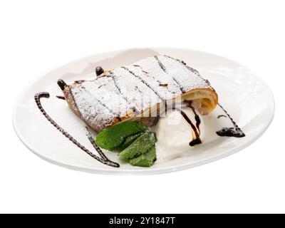 Dekadenter Apfelstrudel mit Vanilleeis und Schokoladentropfen auf eleganter weißer Platte. Stockfoto
