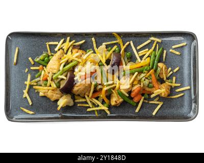 Lebendiges, gebratenes Hühnchen und Gemüse mit knusprigen Strohhalmen auf elegantem Teller. Stockfoto