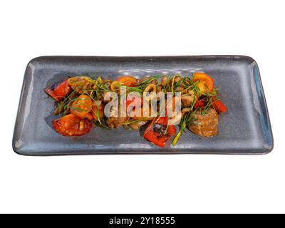 Gourmet-Medley mit gebratenem Rindfleisch und Gemüse auf eleganter grauer Platte. Stockfoto