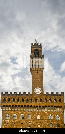 Hoher Teil des Palazzo Vecchio, Rathaus von Florenz, mit dem Turm von Arnolfo vor bewölktem Himmel, Florenz, Toskana, Italien Stockfoto