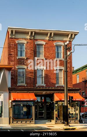 Nyack, NY - USA - 5. September 2024 Ein historisches Gebäude aus rotem Backstein mit Friseur an der Main Street im Dorf Nyack bei Sonnenuntergang. Stockfoto