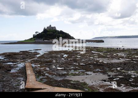 St. Michael's Mount bei Marazion in Cornwall aus dem Meeresspiegel, während Touristen bei Ebbe über den Damm schwärmen Stockfoto