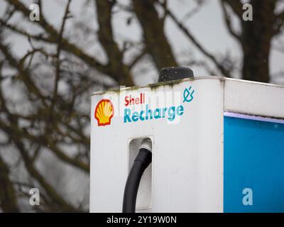 Shell-Aufladelogo auf einer Ladestation für Elektrofahrzeuge. Marke des Öl- und Gasunternehmens, das Strom für Elektroautos liefert. Stockfoto
