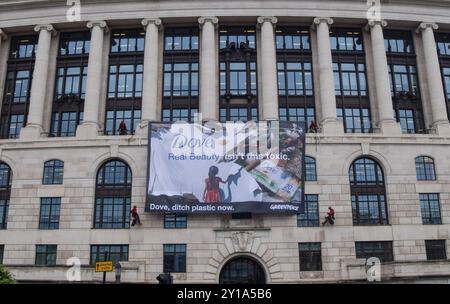 London, Großbritannien. September 2024. Greenpeace-Aktivisten entfalten ein massives Banner auf dem Unilever-Hauptquartier. Aktivisten blockierten auch die Eingänge zum Gebäude und sperrten sich in riesige Nachbildungen von Dove Deodorant Sticks ein, um gegen die Plastikverschmutzung durch Dove Produkte zu protestieren. Quelle: Vuk Valcic/Alamy Live News Stockfoto