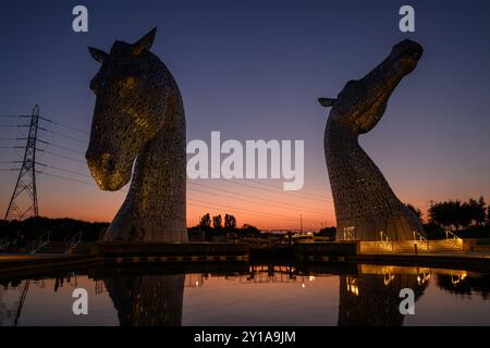 Berühmte schottische Touristenattraktion, die Kelpies, reflektieren im Wasser im Helix, Grangemouth, Falkirk, Schottland, Großbritannien bei Sonnenuntergang. Stockfoto